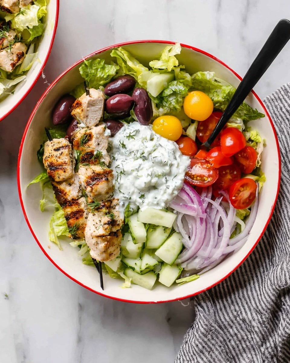 A white bowl with a red rim holds a fresh salad layered in sections starting with chopped green lettuce at the bottom, topped on one side with small dark purple olives, next to two grilled chicken skewers with light brown grill marks placed in the center. On the right side, there are chopped pale green cucumber pieces and thin slices of light purple onion. Bright red and yellow halved cherry tomatoes add a pop of color near the bottom right. A dollop of creamy white tzatziki sauce with visible herb flecks sits on top of the cucumber and onions. A black fork rests inside the bowl, and the bowl is set on a white marbled surface next to a gray and white striped cloth. photo taken with an iphone --ar 4:5 --v 7