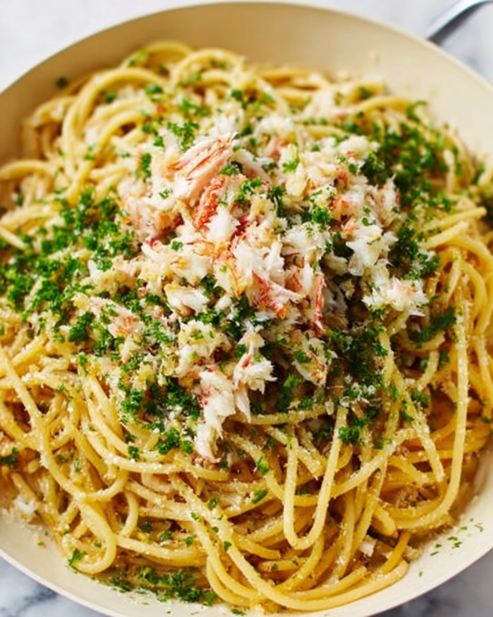 A close-up view of a white bowl filled with golden-yellow spaghetti noodles topped with a mix of finely chopped white crab meat and a sprinkle of chopped green herbs. The noodles are slightly twirled and the crab meat is softly piled in the middle and spread unevenly around. The green herbs add a fresh contrast on top and around the edges, giving texture and color to the dish. The bowl is on a white marbled surface. Photo taken with an iphone --ar 4:5 --v 7