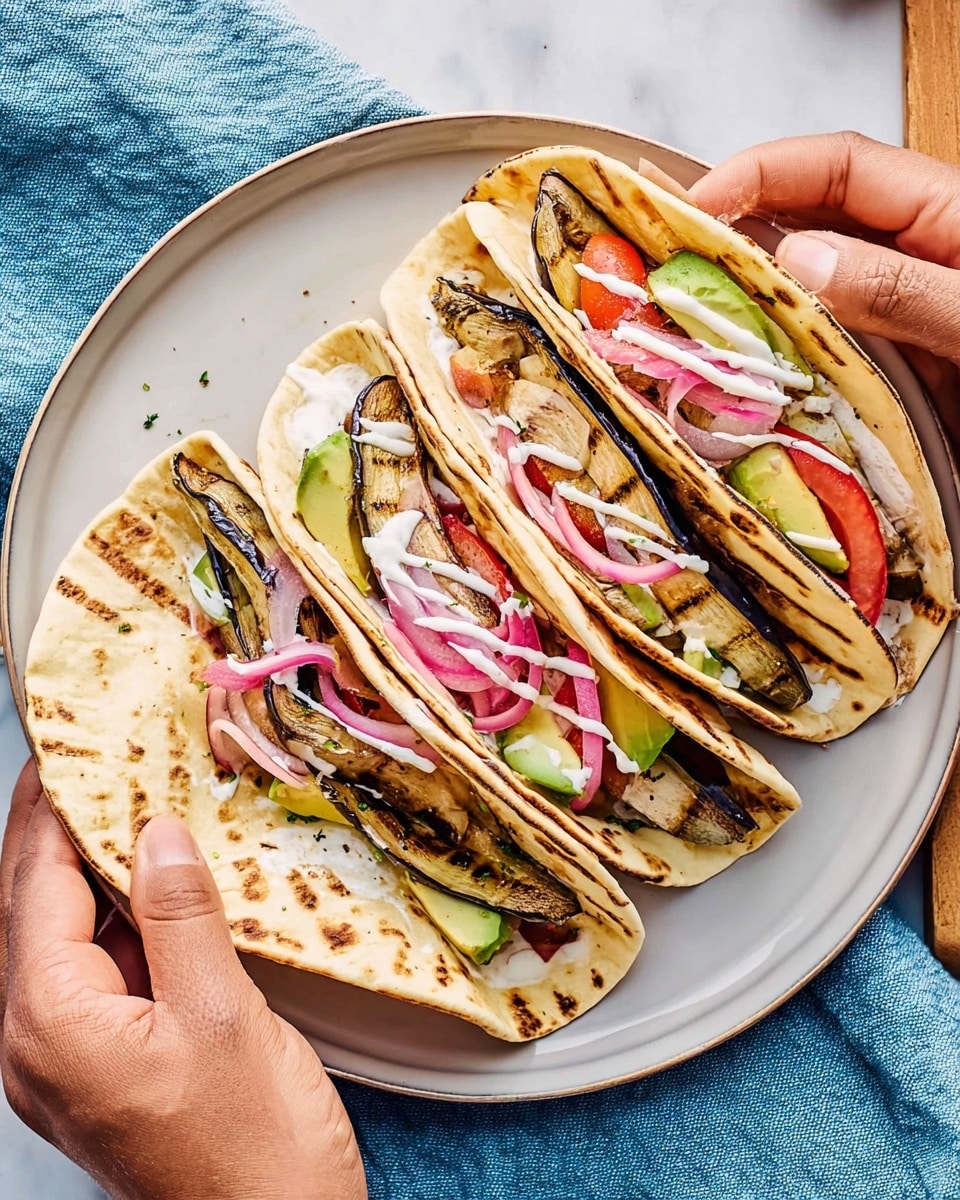 Four folded tortillas with light brown grill marks are placed on a white plate. Each tortilla wrap has visible layers: a base layer of grilled dark brown eggplant slices, a middle layer of bright red tomato slices and light green avocado slices, and a top layer of thin pickled purple onions and white sauce drizzles. Two hands are holding two wraps, one on each side of the plate. The plate is set on a white marbled surface with a soft blue cloth nearby. photo taken with an iphone --ar 4:5 --v 7