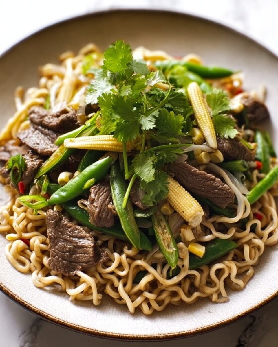 The image shows a black round plate filled with a serving of stir-fried noodles. The dish has thick, light beige noodles as the base layer mixed evenly with small pieces of cooked beef that are brown and slightly glossy. Scattered throughout the noodles are vibrant baby corn in pale yellow, thin green slices of green beans, and small chunks of red chili adding bright color. On top, there is a fresh layer of green cilantro leaves and thin slices of pale green onion, adding a fresh and crisp look. The background is a white marbled texture. The photo is taken with an iphone --ar 4:5 --v 7