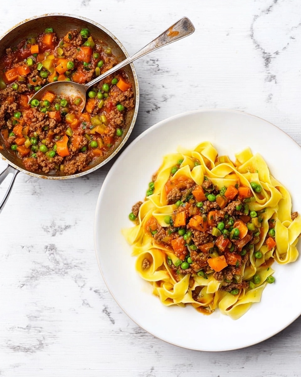 The image shows a white plate with a neat pile of yellow pasta ribbons topped with a colorful mix of chunky sauce made from small green peas, diced orange carrots, and brown meat pieces. Next to the plate, there is a small metal pan with a black handle, containing more of the same sauce with a silver spoon in it. The entire scene is set on a white marbled surface. photo taken with an iphone --ar 4:5 --v 7