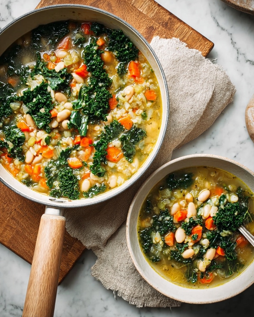 A white pan with a wooden handle sits on a beige cloth and wooden board on a white marbled surface, filled with a colorful soup showing layers of dark green kale leaves, bright orange carrot cubes, light beige chickpeas, and small white barley grains, all mixed in a light yellow broth. Next to the pan is a white bowl placed on a white plate holding the same soup, showing the same mix of kale, carrot, chickpeas, and barley with visible leafy and chunky textures. photo taken with an iphone --ar 4:5 --v 7