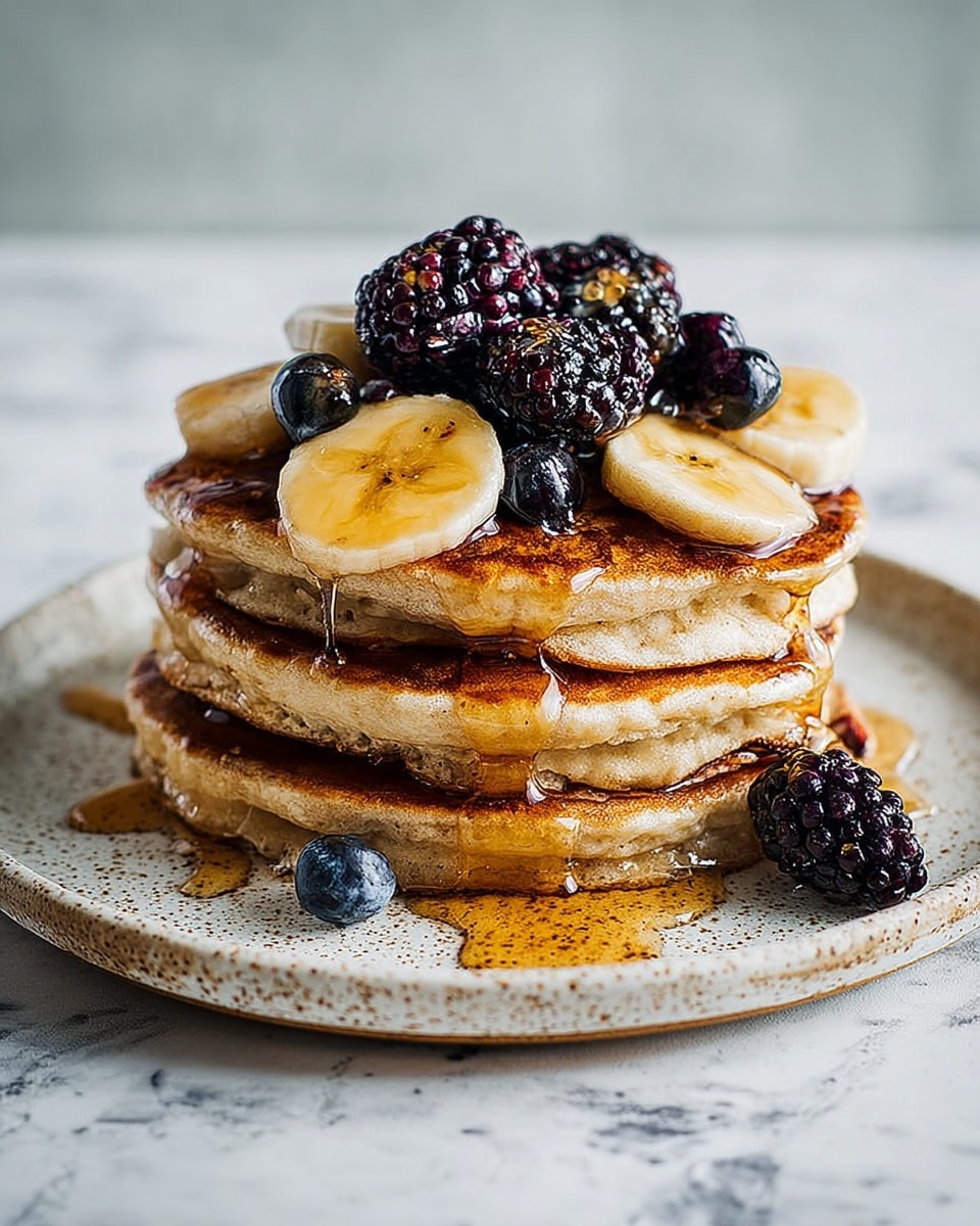 A stack of three golden-brown pancakes sits on a white speckled plate on a white marbled surface. Between each pancake layer, there are slices of light yellow banana, dark purple blackberries, and deep blue blueberries. The top pancake is covered with more banana slices, blackberries, and blueberries, all dripping with shiny amber syrup cascading down the sides. Extra blackberries are scattered around the plate, adding contrast to the soft texture of the pancakes. photo taken with an iphone --ar 4:5 --v 7