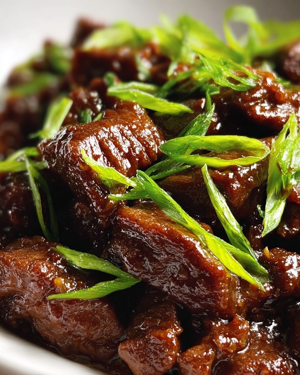 The image shows a close-up of dark brown, glossy cooked beef pieces layered thickly with a rich, sticky sauce coating each piece. Bright green sliced scallions are scattered generously on top, adding a fresh and crisp texture contrast. The beef looks tender with a slightly rough texture, and the sauce gives it a shiny, moist appearance. The background is a white marbled texture, softly blurred to keep focus on the beef and greens. photo taken with an iphone --ar 4:5 --v 7